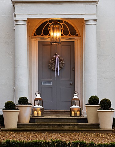 WHITE_HOUSE_NIGHT_VIEW_OF_HOUSE_FRONT_WITH_PALE_GREY_FRONT_DOOR_DECORATED_WITH_WHITE_GYPSOPHILA_CHRI