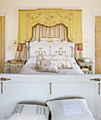 SARAH BAKERS HOUSE  THE OLD VICARAGE: MASTER BEDROOM : DECORATIVE VINTAGE BED AND GOLD VINTAGE SILK CANOPY WITH CUSHIONS FROM BAKER AND GRAY.