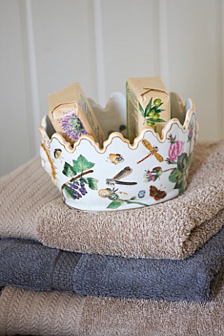 SARAH_BAKERS_HOUSE__THE_OLD_VICARAGE_BATHROOM_STACK_OF_TOWELS_WITH_DECORATIVE_CACHEPOT