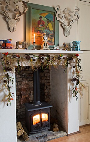 SARAH_BAKERS_HOUSE__THE_OLD_VICARAGE_THE_FAMILY_ROOM_LOG_BURNING_STOVE_WITH_DEERS_HEAD_WOOD_BARK_WAL