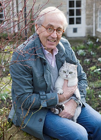 DR_RONALD_MACKENZIE__OXFORDSHIRE_DR_RONALD_MACKENZIE_IN_HIS_GARDEN_IN_JANUARY_WITH_HIS_CAT_HARRIS