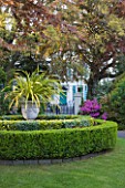 GRANGE COURT  GUERNSEY: VIEW TO COLONIAL STYLE HOUSE WITH BOX CIRCLES AND URN PLANTED WITH PHORMIUM