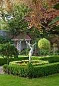 GRANGE COURT  GUERNSEY: SCULPTURE WELCOME THE NEW YEAR BY EVERARD MEYNELL IN BOX BEDS WITH LAWN  COPPER BEECH AND SUMMER HOUSE BEHIND