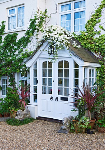 MILLE_FLEURS__GUERNSEY_THE_FRONT_OF_THE_HOUSE_WITH_CLEMATIS_AND_PHORMIUMS