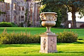 NYMANS  SUSSEX. THE NATIONAL TRUST: URN ON MAIN LAWN WITH THE HOUSE BEHIND  EVENING LIGHT  JUNE