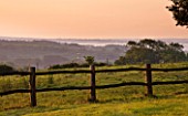 NYMANS  SUSSEX. THE NATIONAL TRUST: WOODEN FENCE AND VIEWS OUT TO COUNTRYISED AT DAWN  JUNE