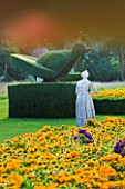 THE NATIONAL TRUST: CLIVEDEN  BUCKINGHAMSHIRE: STATUE  TOPIARY AND BOX EDGED BEDS PLANTED WITH RUDBECKIA  IN THE LONG GARDEN  EVENING LIGHT