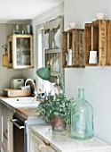 TWIG HUTCHINSON HOUSE  LONDON: KITCHEN WITH GREEN GLASS JAR AND FRUIT BOXES ON WALL