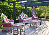 THE BOAT HOUSE: DESIGNER ARLETTE GARCIA - DECKED SEATING AREA WITH FURNITURE BY AMERICAN COMPANY MACKENZIE CHILDS - THE FLOWER MARKET RANGE OF HAND WOVEN RESIN WICKER