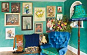 VELVET ECCENTRIC: NEW COUNTRY LOOK - PERSIAN GREEN GLAZED WALLS  1930S GYPSY DOOR CURTAINS  FLORAL OIL PAINTINGS COLLECTED BY HANNAH BAUD  LAMP AND BLUE CHAIR BY VELVET ECCENTRIC