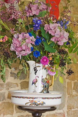 VELVET_ECCENTRIC_GARDEN_ROOM__JUG_AND_BOWL_WITH_DISPLAY_OF_FLOWERS_AND_FOLIAGE