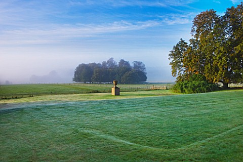 RAGLEY_HALL_GARDEN__WARWICKSHIRE_STATUE_AND_PARKLAND_IN_MIST__EARLY_MORNING