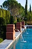 AFRICAN GARDEN  PROVENCE  FRANCE: DESIGNER DOMINIQUE LAFOURCADE: WATER FOUNTAINS SPURTING INTO THE SWIMMING POOL