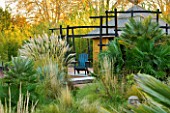AFRICAN GARDEN  PROVENCE  FRANCE: DESIGNER DOMINIQUE LAFOURCADE: PAMPAS GRASS  THATCHED HUT AND BLACKENED WOOD FENCING