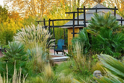 AFRICAN_GARDEN__PROVENCE__FRANCE_DESIGNER_DOMINIQUE_LAFOURCADE_PAMPAS_GRASS__THATCHED_HUT_AND_BLACKE
