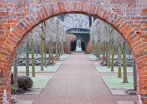 HAMPTON_COURT_CASTLE_AND_GARDENS__HEREFORDSHIRE_VIEW_THROUGH_BRICK_ARCH_IN_THE_WALLED_GARDEN_IN_FROS