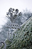 HAMPTON COURT CASTLE AND GARDENS  HEREFORDSHIRE: ORNATE METAL FLOWER DECOARATION ON TOP OF GATE IN WALLED GARDEN IN FROST