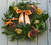 THE GARDEN AND PLANT COMPANY  HATHEROP  GLOUCESTERSHIRE: NATURAL FIR WREATH DECORATED WITH HOLLY  ROSEMARY  DRIED ORANGES  PINE CONES  CINNAMON STICKS AND CHILLI PEPPERS