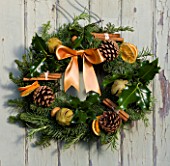 THE GARDEN AND PLANT COMPANY  HATHEROP  GLOUCESTERSHIRE: FIR WREATH DECORATED WITH HOLLY  ROSEMARY  DRIED ORANGES  PINE CONES  CINNAMON STICKS AND CHILLI PEPPERS