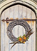 THE GARDEN AND PLANT COMPANY  HATHEROP  GLOUCESTERSHIRE: NATURAL TWIG WREATH DRESSED WITH HOLLY PINE CONES  DRIED ORANGES AND LIMES  CINNAMON  PHEASANT FEATHERS
