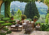 VILLA FORT FRANCE  GRASSE  FRANCE: A PLACE TO SIT - TERRACE BY THE VILLA WITH TABLE AND CHAIRS AND VIEW TO HILLS BEYOND