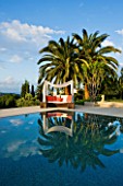 DESIGNER JAMES BASSON, SCAPE DESIGN, FRANCE: SKY REFLECTED IN SWIMMING POOL WITH CANOPY OVER SUN LOUNGER- WATER, REFLECTION, REFLECTIONS, PALM TREE, RELAX, RELAXING