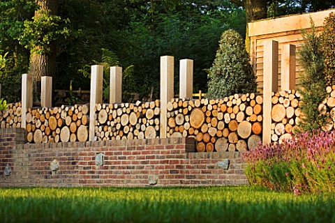 GARDEN_IN_KENT_DESIGNED_BY_BELLA_WHITELEY_LOG_WALL_BEHIND_BRICK_WALL_RECYCLING_RECYCLED_FENCE_FENCIN
