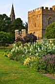 BROUGHTON CASTLE, OXFORDSHIRE: HERBACEOUS BORDER ALONG THE GARDEN WALL WITH THE GATEHOUSE AND CHURCH BEHIND - FLOWERS, SUMMER, FLOWERING, ENGLISH GARDEN, COUNTRY GARDEN