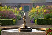 HELMSLEY WALLED GARDEN  YORKSHIRE: THE HERBACEOUS BORDER IN JULY IN DAWN LIGHT  DOMINATED BY VERBASCUMS - FOUNTAIN IN FOREGROUND