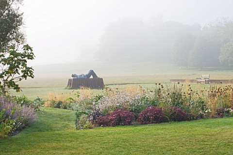 GLYNDEBOURNE_EAST_SUSSEX_THE_MAIN_LAWN_IN_MIST_WITH_SCULPTURE_IN_BRONZE_AND_COR__TEN_STEEL_BY_SEAN__