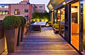 ROOF GARDEN IN SHOREDITCH  LONDON  DESIGNED BY AMIR SCHLEZINGER OF MY LANDSCAPES: DECKING  BUDDHA STATUE  DECK CHAIRS  BOX BALLS IN CONTAINERS  LIT UP AT NIGHT  LIGHTING