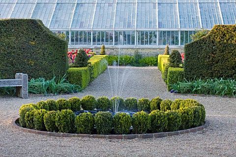 ARUNDEL_CASTLE_GARDENS_WEST_SUSSEX_THE_WALLED_GARDENS_CIRCULAR_BOX_FOUNTAIN_WITH_OAK_SEATS_BENCHES_A