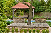ARALIA GARDEN DESIGN - PATRICIA FOX: WEDNESDAY HOUSE: WOODEN TREE SEAT, STONE WALL, WOODEN LOGGIA AND SWIMMING POOL