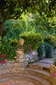 SICILY  ITALY: CASA CUSENI IN TAORMINA - ENTRANCE TO THE LOWER GARDEN WITH TERRACOTA TILED PATH  STEPS AND STONE WALL  RAISED BED  MEDITERRANEAN