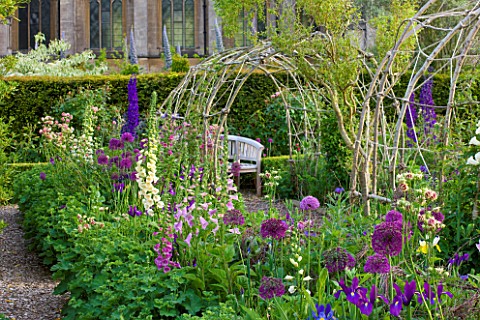 ARUNDEL_CASTLE_GARDENS__WEST_SUSSEX_THE_COLLECTOR_EARLS_GARDEN_VIEW_ALONG_BORDER_WITH_ALLIUMS_AND_FO