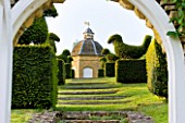 ROCKCLIFFE HOUSE  GLOUCESTERSHIRE: VIEW THROUGH THE WALLED VEGETABLE/ KITCHEN GARDEN WITH STONE DOVECOT AND TOPIARY BIRDS