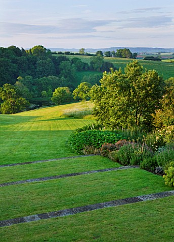 BROCKHAMPTON_COTTAGE_HEREFORDSHIRE_LAWN_AND_TERRACING_WITH_BORDER_AND_VIEW_TO_COUNTRYSIDE_BEYOND__CO