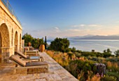 CORFU, GREECE - THE KASSIOPIA ESTATE: VIEW FROM THE STONE TERRACE OUT TO SEA WITH THE ALBANIAN MOUNTAINS IN THE DISTANCE
