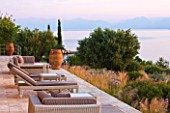 CORFU, GREECE - THE KASSIOPIA ESTATE: THE SUN TERRACE WITH VIEW OUT TO SEA AND THE ALBANIAN MOUNTAINS IN THE DISTANCE