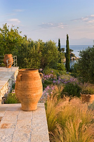 CORFU_GREECE__THE_KASSIOPIA_ESTATE_THE_STONE_TERRACE_LOOKING_OUT_TO_SEA_WITH_GARDEN_TERRACOTTA_URNS_
