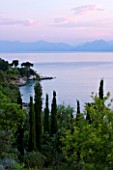 CORFU, GREECE - THE KASSIOPIA ESTATE. VIEW OF THE BAY LOOKING OUT TO SEA WITH OLIVE AND CYPRESS TREES AND ALBANIAN MOUNTAINS IN THE DISTANCE