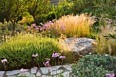 CORFU,GREECE-THE KASSIOPIA ESTATE.THE GARDEN WAS DESIGNED BY JENNIFER GAY, USING STONE AND A NATURALISTIC PLANTING SCHEME.WITH STIPA TENUISSIMA AND TULBAGHIA VIOLACEA.HOT,DRY