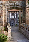 BIRTSMORTON COURT, WORCESTERSHIRE: VIEW THROUGH ARCHWAY ACROSS THE BRIDGE TO THE COURTYARD BESIDE THE COURT IN SUMMER