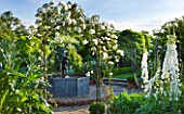 BIRTSMORTON COURT, WORCESTERSHIRE: WHITE GARDEN - LEAD POOL / POND WITH CHERUB FOUNTAIN, WHITE DELPHINIUMS AND METAL ARCH WITH ROSE ICEBERG. COUNTRY GARDEN, CLASSIC, ENGLISH
