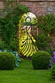 BIRTSMORTON COURT, WORCESTERSHIRE: THE ANGEL GATE IN THE WALLED GARDEN LOOKING OVER THE MALVERN HILLS. MADE BY MIKE ROBERTS, WALL, ENGLISH GARDEN, EVENING LIGHT, DUSK, ORNAMENT