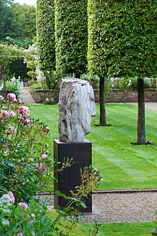 POULTON_HOUSE_GARDEN_WILTSHIRE_GRAVEL_PATH_LEADS_AROUND_THE_EDGE_OF_THE_WALLED_GARDEN_WITH_CLIPPED_Q