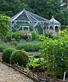 POULTON HOUSE GARDEN, WILTSHIRE: THE KITCHEN GARDEN WITH FRUIT CAGE, ROSES AND VEGETABLE BORDERS. POTAGER