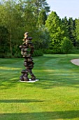 POULTON HOUSE GARDEN, WILTSHIRE: THE LAWN BETWEEN THE RILLS AND MAIN DRIVE WITH ABSTRACT BRONZE SCULPTURE CHAIN OF EVENTS BY TONY CRAGG