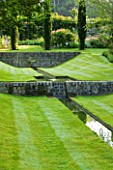 POULTON HOUSE GARDE, WILTSHIRE: WATER FEATURE. A DESCENDING FLIGHT OF RILLS SET INTO SUNKEN LAWN WITH JUNIPER TREES