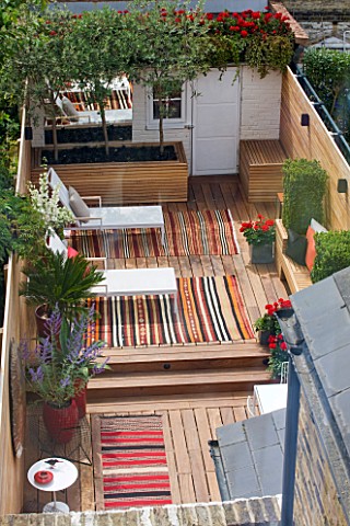 BEN_DE_LISI_HOUSE_AND_GARDEN_LONDON_VIEW_ONTO_GARDEN_WITH_CARPETS_DECKING_DECK_CHAIRS_SHED_LOUNGERS_